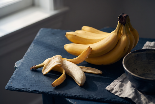 Ripe bananas with one partly peeled on dark slate, the banana note in fragrance