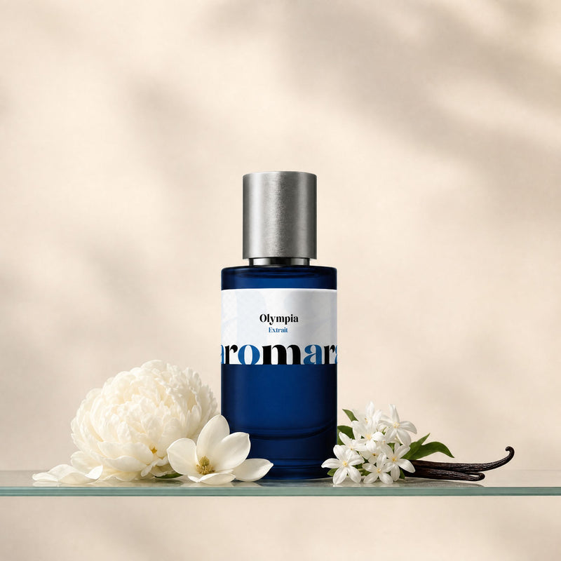 Aromara Olympia Extrait perfume bottle on glass shelf with white peony, magnolia petals, jasmine and vanilla pod on soft cream background