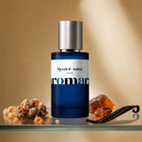 Myrrh and Amber by Aromara, 35% extrait perfume bottle on a glass shelf with myrrh resin, raw amber and vanilla pod accents