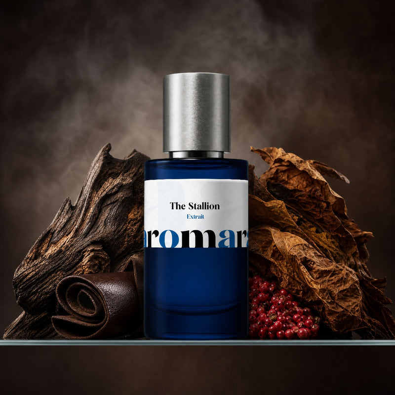 Aromara The Stallion Extrait perfume bottle with oud wood, brown leather, tobacco leaves, and pink peppercorns on a clear glass shelf, smoky deep brown backdrop