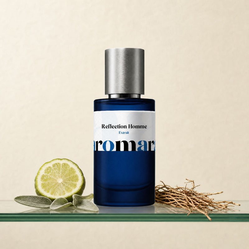 Reflection Homme by Aromara, 35% extrait perfume bottle on a glass shelf with halved bergamot, sage leaves and vetiver root accents