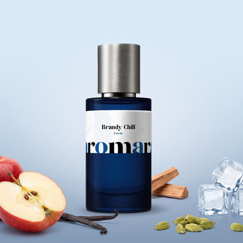 Brandy Chill by Aromara on a pale frosted ice blue to soft steel blue background with a red apple, ice cubes, sandalwood, vanilla pods and cardamom pods. 35% Extrait, inspired by Kilian Apple Brandy on the Rocks.