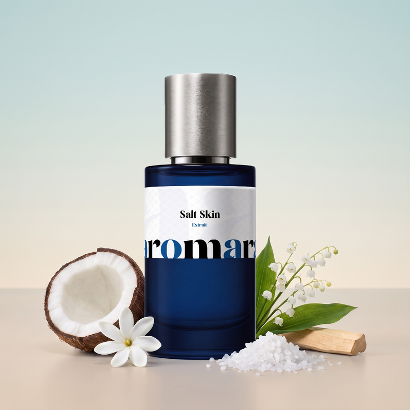 Salt Skin by Aromara on a pale sea-mist blue to soft sand beige background with a halved coconut, a tiare flower, sea salt crystals, lily of the valley and sandalwood. 35% Extrait, inspired by Phlur Beach Skin.