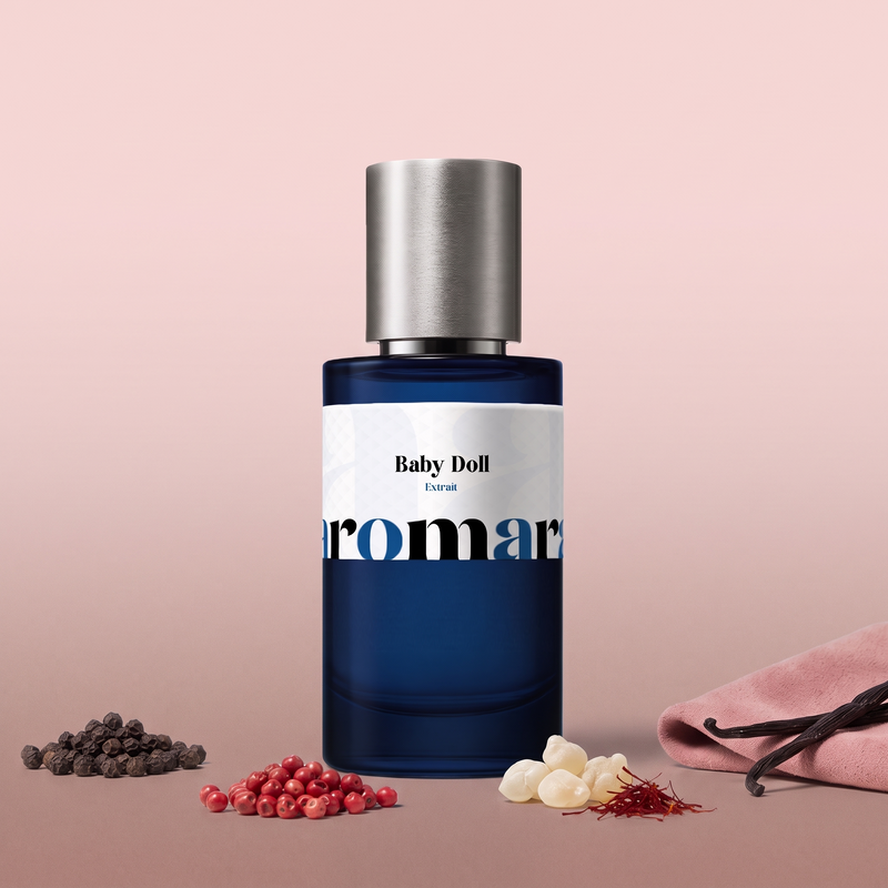 Baby Doll by Aromara on a pale ballet pink to soft rose-taupe background with black and pink peppercorns, frankincense tears, saffron threads, pink suede and vanilla pods. 35% Extrait, inspired by Yves Saint Laurent Baby Cat.