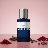 Ardour by Aromara on a pale rosewood pink to soft garnet rose background with saffron threads, oud wood chips, vanilla pods, red rose petals and dark resin. 35% Extrait, inspired by Boadicea the Victorious Ardent.
