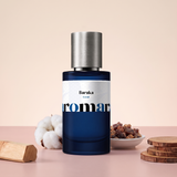 Baraka by Aromara on a pale almond cream blush to soft clay rose background with sandalwood, a cotton boll, benzoin resin and warm wood slices. 35% Extrait, inspired by Initio Blessed Baraka.