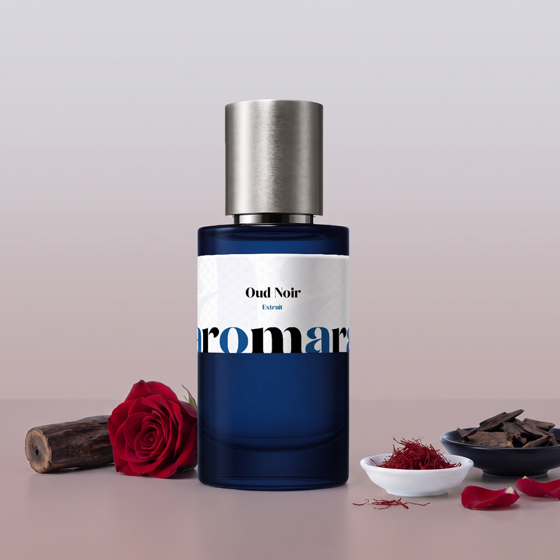 Oud Noir by Aromara on a pale dove grey to dusty rose taupe background with oud wood, a deep red rose, saffron threads, oud wood chips and rose petals. 35% Extrait, inspired by Maison Francis Kurkdjian Oud.