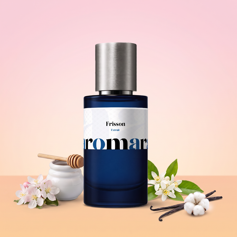Frisson by Aromara on a pale apple blossom pink to soft orange blossom peach background with apple blossom, a honey pot and dipper, orange blossom, vanilla pods and white cotton. 35% Extrait, inspired by Initio Addictive Vibration.