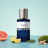 Coral Sea by Aromara on a pale sea-glass aqua to soft ocean teal background with pink grapefruit, lime, lemon, rosemary, green moss and sandalwood. Up to 35% Extrait, inspired by Roja Oceania.