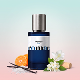 Olympia by Aromara on a pale salt-mist aqua to soft vanilla blush pink background with vanilla pods on sea salt, a halved mandarin, jasmine, a ginger lily and sandalwood. 35% Extrait, inspired by Paco Rabanne Olympea.