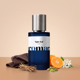 Night Rail by Aromara on a pale warm sandstone to soft saddle tan background with soft brown leather, vetiver roots, a halved mandarin, cardamom pods and jasmine flowers. Up to 35% Extrait, inspired by Ex Nihilo Chandigarh Express.